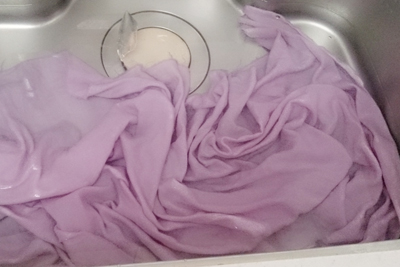 染めた布を台所シンクで洗う